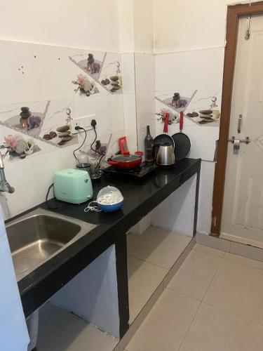 a kitchen with a sink and a counter top with pots and pans at SAI POOJITHA SERVICE APPARTMENT in Gachibowli