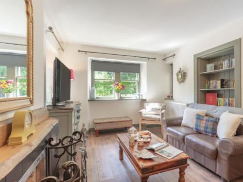 a living room with a couch and a table at Gate Lodge with Hot Tub in Fettercairn