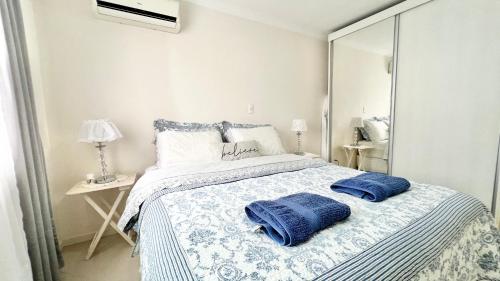 um quarto com uma cama com duas almofadas azuis em Apto Próximo a Vila Germânica em Blumenau