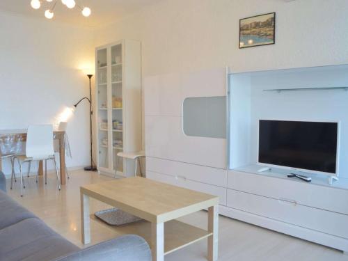 un salon avec un canapé, une télévision et une table dans l'établissement Appart familial 6 pers Banyuls-sur-Mer clim, parking privé, proche plages - FR-1-225C-57, à Banyuls-sur-Mer