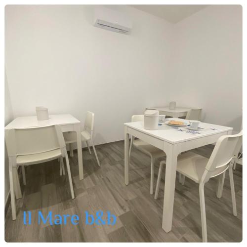 a white dining room with white tables and chairs at Il mare b&b in Quartu SantʼElena
