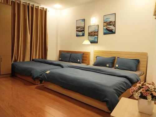 sypialnia z 2 łóżkami i niebieską pościelą w obiekcie Da Tree Homestay w mieście Hanoi