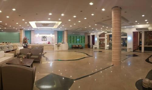a lobby of a hotel with a table and chairs at Mayflower Grande Hotel Phitsanulok in Phitsanulok