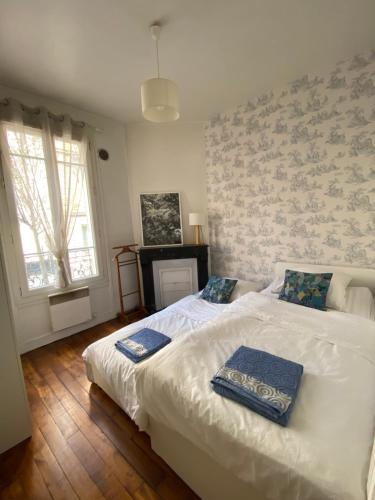1 dormitorio con 1 cama con 2 almohadas en Paris en 10 min, T3 dans le centre ville de Puteaux, en Puteaux