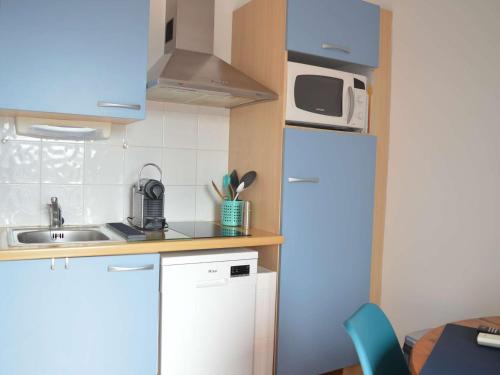 une petite cuisine avec un réfrigérateur et un micro-ondes dans l'établissement Appart T1 à 250m Plage, Clim, Wifi, Parking, Centre Banyuls - FR-1-225C-75, à Banyuls-sur-Mer