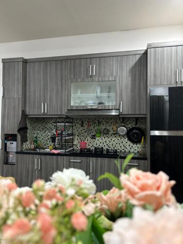 a kitchen with wooden cabinets and flowers in the foreground at Five Leo’s villa in Gadok 1
