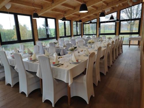 a banquet hall with white tables and chairs at Hotel Poutní Dům in Králíky