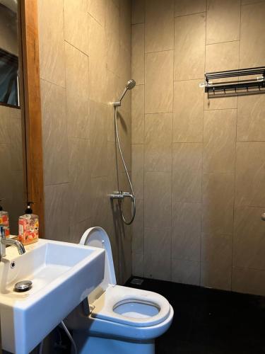 a bathroom with a white sink and a toilet at Five Leo’s villa in Gadok 1