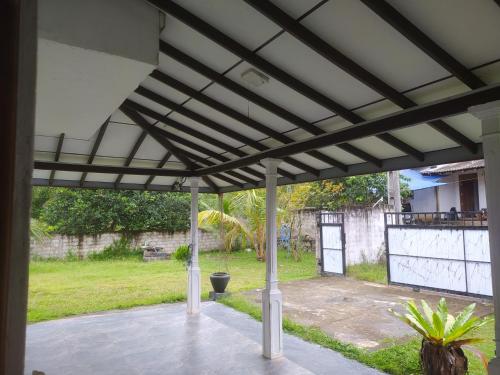 a patio with awning over a yard with plants at SuPra Villa in Ginimellagaha West