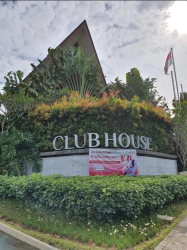 a sign for a club house with plants on it at Five Leo’s villa in Gadok 1