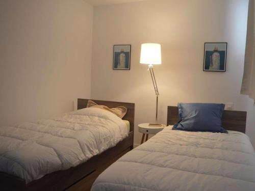 a bedroom with two beds next to a lamp and a table at Appartement Banyuls-sur-Mer, 3 pièces, 5 personnes - FR-1-225C-77 in Banyuls-sur-Mer