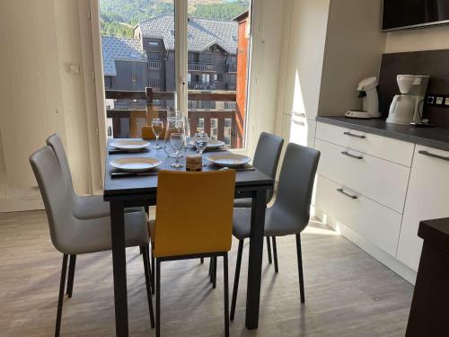 - une table à manger avec des chaises et des verres à vin dans l'établissement Superbe T3 skis aux pieds, centre station, 6 personnes - FR-1-330-524, à Risoul