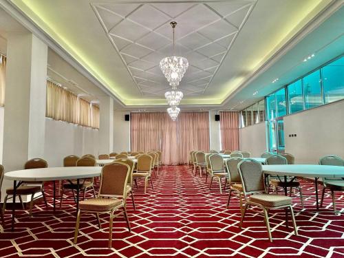 Base Ethiopia International Hotel في أديس أبابا: قاعة اجتماعات مع طاولات وكراسي وثريا