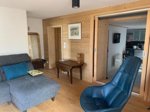 - un salon avec un canapé bleu et une table dans l'établissement Le Sarana : 75m2, calme, belle vue avec terrasse., à Les Deux Alpes
