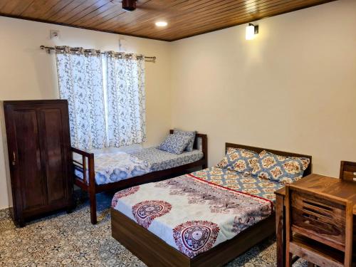 a bedroom with two beds and a table at Sunny Smiles in Mangalore