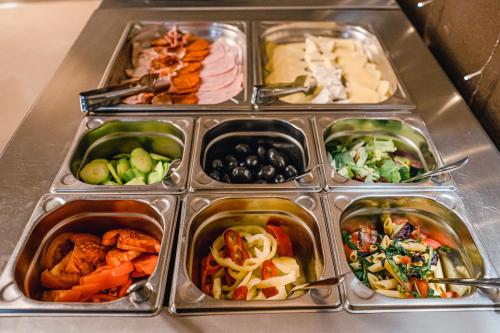 a bunch of trays filled with different types of food at Caro Boutique Hotel in Oradea