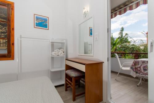 a bedroom with a desk and a balcony at STAR PARADISE Studios in Neos Marmaras