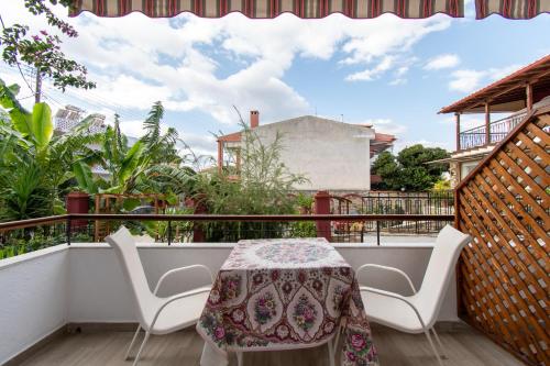 a balcony with a table and chairs on a balcony at STAR PARADISE Studios in Neos Marmaras