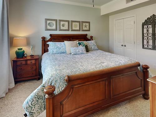 a bedroom with a large wooden bed with blue pillows at Dawn 315-saltwater Escape in Galveston