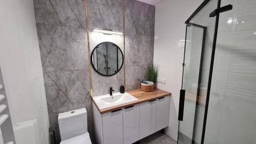 a bathroom with a sink and a mirror at Apartament - Sienkiewicza 22D in Zamość