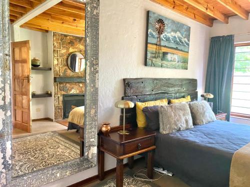 a bedroom with a blue bed and a mirror at Critchely Stone Villa, Dullstroom in Dullstroom