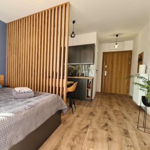 a bedroom with a bed and a wooden wall at Apartament - Sienkiewicza 22D in Zamość