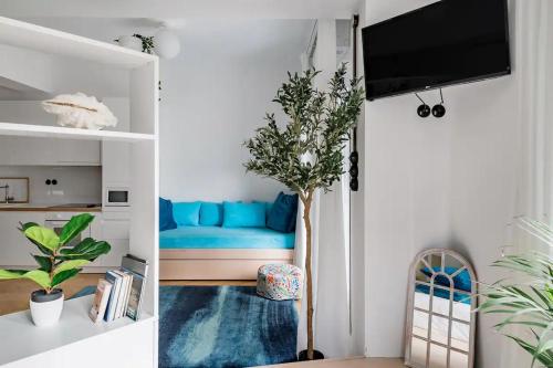 een woonkamer met een blauwe bank en een tv bij Blue City Center Boutique Apartment in Thessaloniki