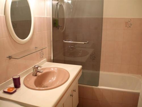 uma casa de banho com um lavatório, um espelho e uma banheira em Appartement Ajaccio, 3 pièces, 6 personnes - FR-1-61-564 em Ajaccio