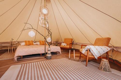 Habitación con tienda de campaña, cama y sillas en Glamping Černická obora, en Sudoměřice