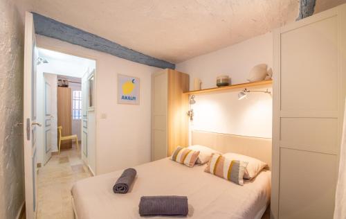 - une petite chambre avec un lit et un couloir dans l'établissement Appartement vieux village - La Ponche, à Saint-Tropez