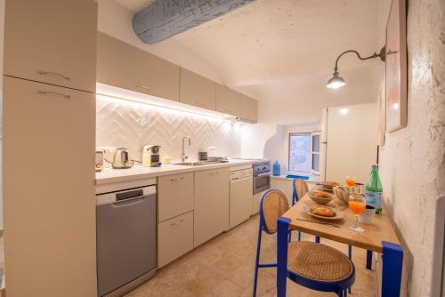 - une cuisine avec une table, des chaises, une table et un comptoir dans l'établissement Appartement vieux village - La Ponche, à Saint-Tropez