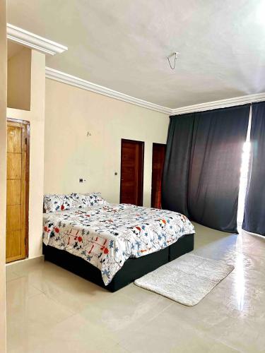 1 dormitorio con cama con edredón en Spacious Private Room & Balcony In Cotonou, en Cotonou