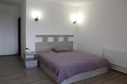 a bedroom with a bed and two lights on the wall at Bears and Berries in Berd