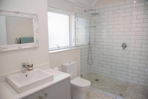 a white bathroom with a sink and a toilet at Waterfront- C25 Knysna Quays with pool in Knysna