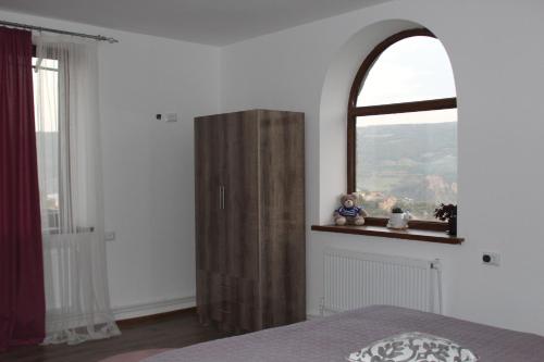 a bedroom with a wooden cabinet and a window at Bears and Berries in Berd