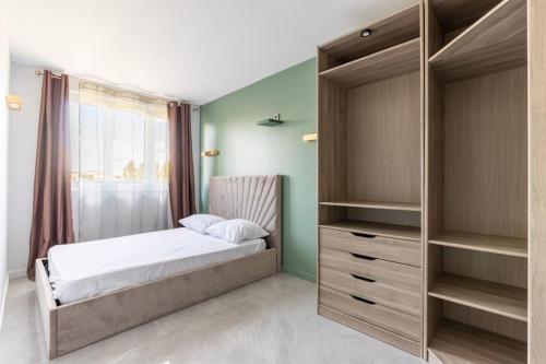 - une chambre avec un lit et un grand placard dans l'établissement Magnifique Appartement avec vue sur la Tour Eiffel, à Bagneux