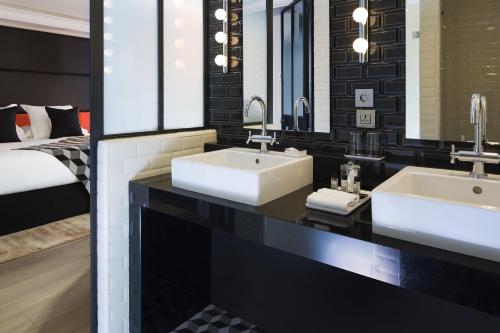 a bathroom with two sinks and a mirror at Terrass" Hotel in Paris