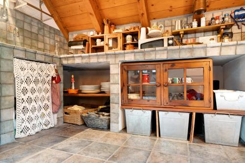 a kitchen with a wooden cabinet and some dishes at Titti in Anzino