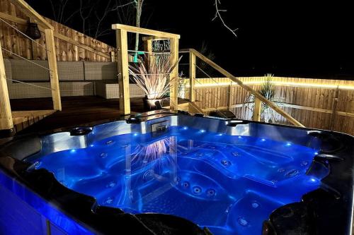 - un bain à remous bleu sur une terrasse la nuit dans l'établissement Chalet et Jaccuzy sur la plage, à Biscarrosse