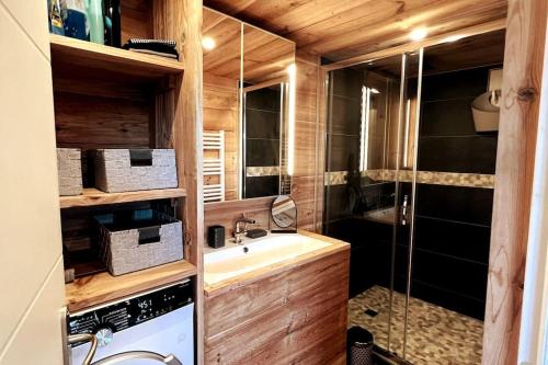 a bathroom with a sink and a shower at Chalet et Jaccuzy sur la plage in Biscarrosse