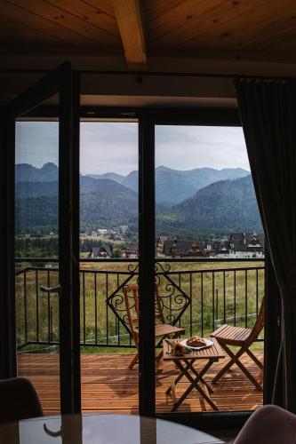 a room with a balcony with a view of the mountains at Apartamenty Górajski Spa in Kościelisko