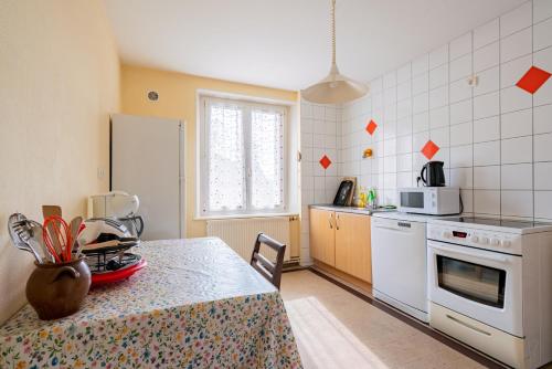 une cuisine avec une table et un comptoir dans l'établissement Le Claudel - Idéal pour découvrir les Vosges, à La Bresse