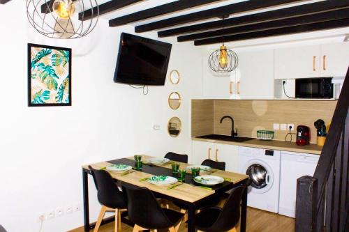 cocina y comedor con mesa y sillas en Maison d'une chambre avec jardin et wifi a Roissy en Brie, en Roissy-en-Brie