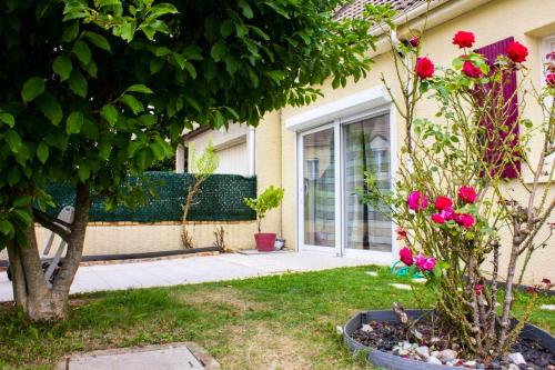 una casa con flores rosas en un patio en Maison d'une chambre avec jardin et wifi a Roissy en Brie, en Roissy-en-Brie