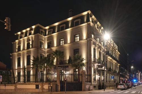 um edifício iluminado numa rua à noite em GA Palace Hotel & Spa, a XIXth-Century Villa no Porto