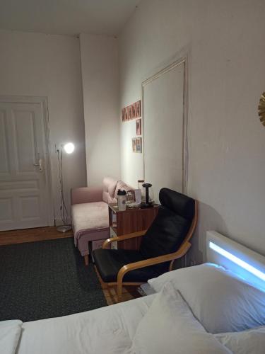 a room with a bed and a chair and a table at Private room in a shared apartment, free parking in Fulda