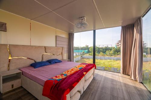um quarto com uma cama e uma grande janela em Bliss Farm Stay- Tulip em Secunderābād
