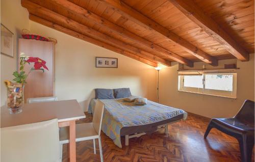 4 Bedroom Nice Home In Marina Di Modica في مارينا موديكا: غرفة نوم بسرير وطاولة وكراسي