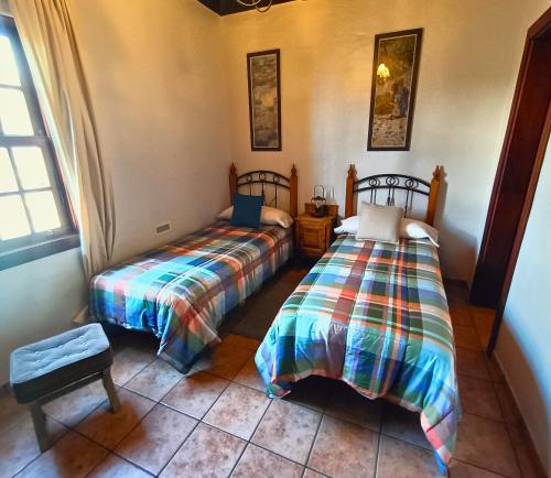 1 dormitorio con 2 camas y ventana en Casa El Aljibe, en Puntagorda