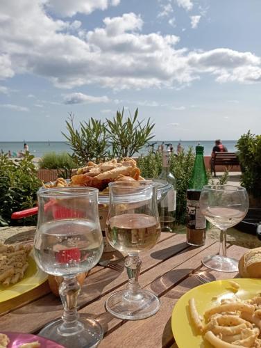 - une table avec des verres de vin et une assiette de nourriture dans l'établissement Face à la mer, appartement pour 4 personnes sur la rive droite, à Palavas-les-Flots